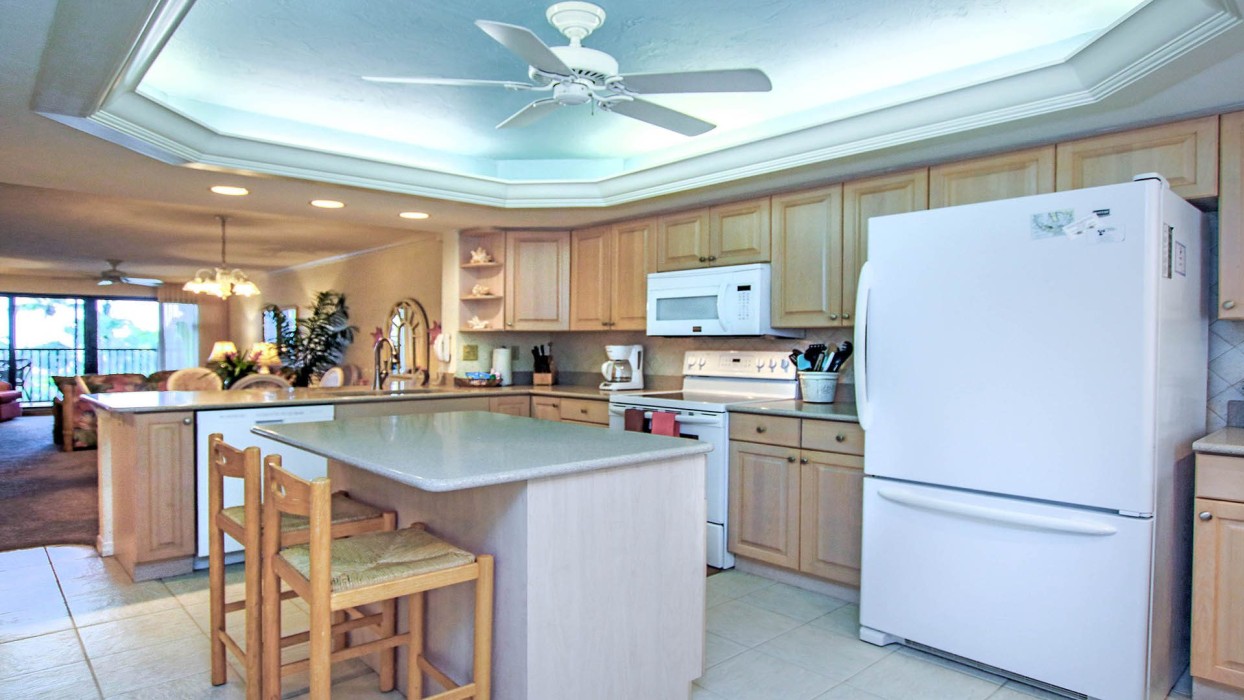 The kitchen cabinets have been painted white, and the new quartz countertops are a pale gray/sand color; new photos will be inserted soon.