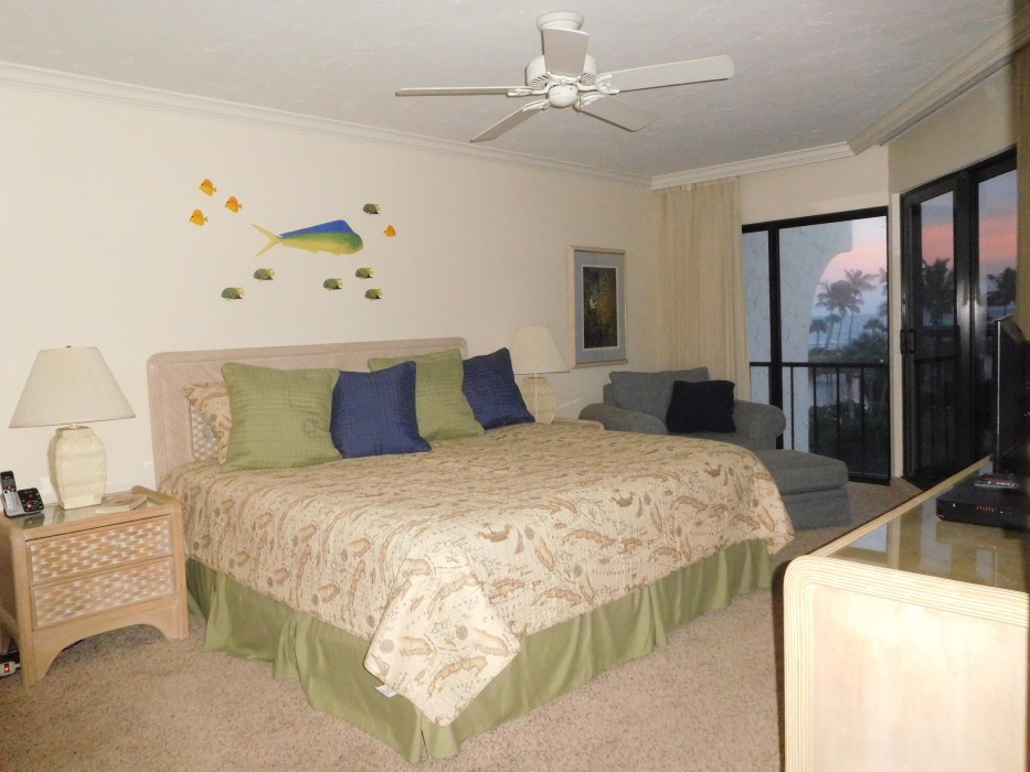 The master bedroom has a king-size bed, flat-screen HDTV, and sliding doors with a view and the soothing sounds of the Gulf surf.  This photo shows a beautiful sunset!