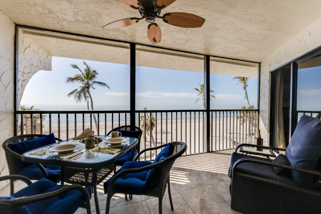 Lanai dining table for four, a cushioned reclining lounge chair and ceiling fan.