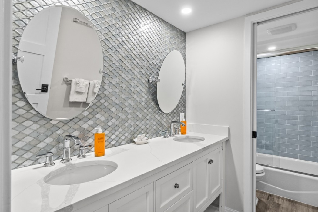 Guest Bathroom features double sink custom spa vanity with plentiful storage, and privacy commode/bathing room