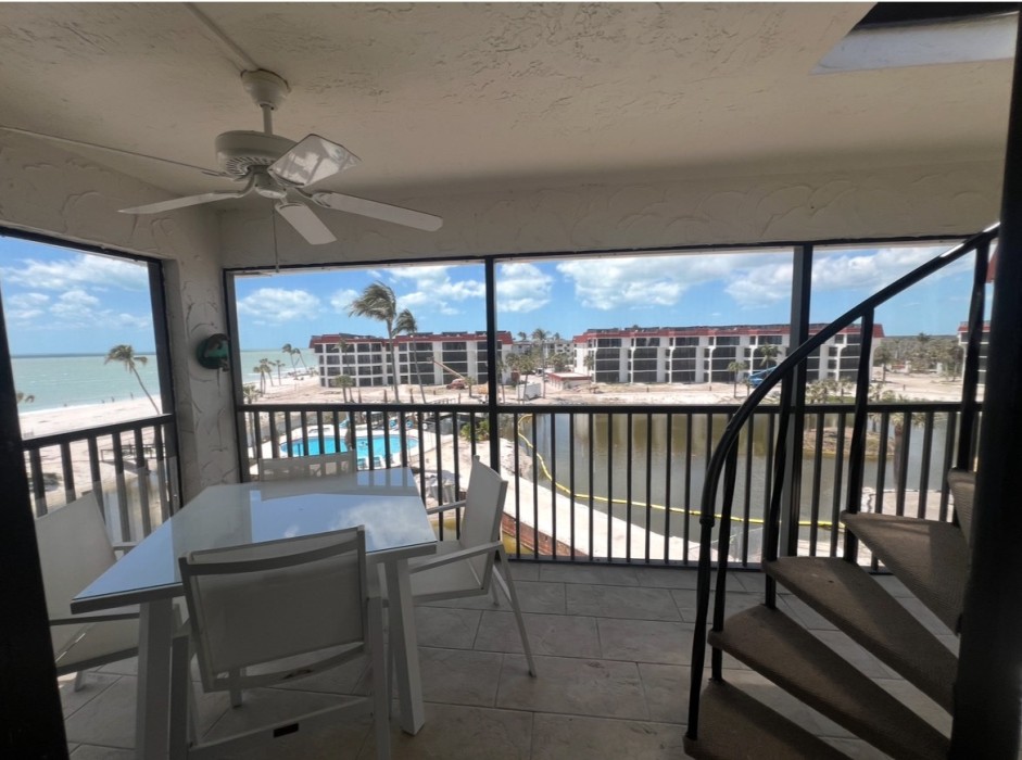 Meals taste great on the screened in lanai; the circular stairs lead up to the private penthouse deck!
