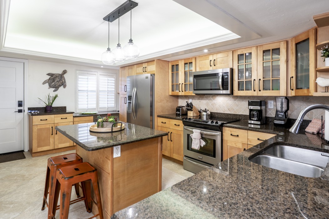 The large, fully equipped kitchen has stainless appliances and granite counters.