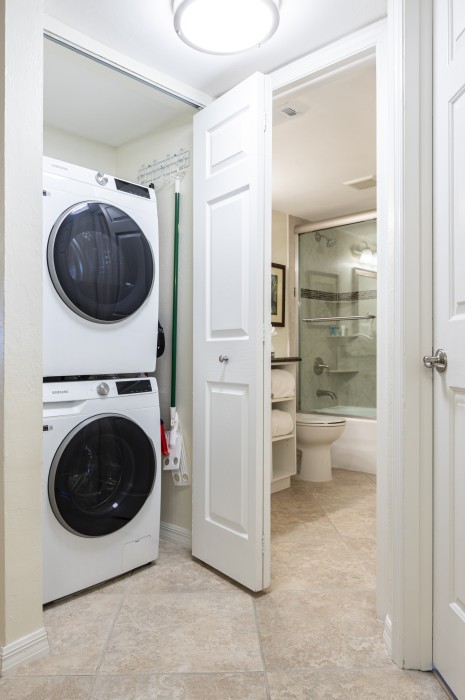 A new washer/dryer is conveniently located in a closet by the kitchen.