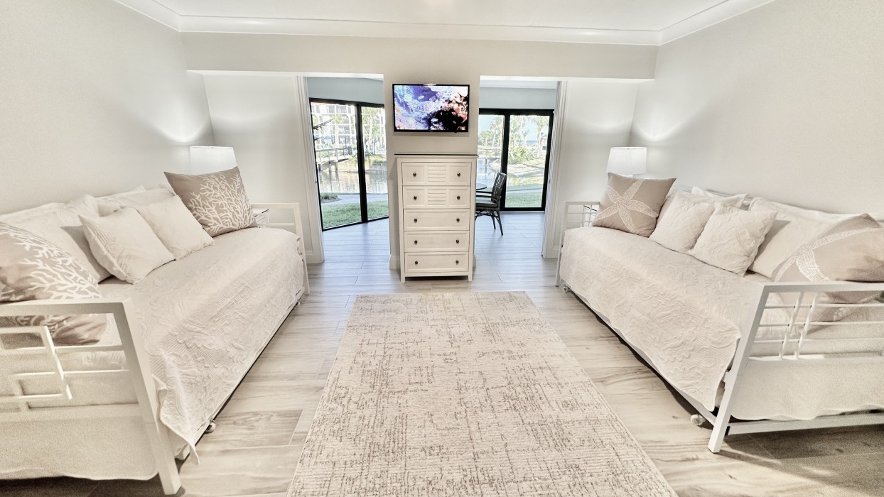The 3rd bedroom features Twin Trundle beds, a Smart TV & pocket doors that open to the sunroom